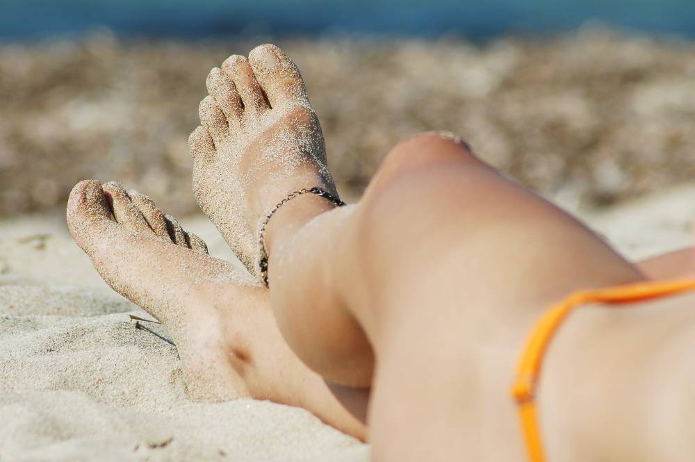 bracelet de cheville discret sur une femme a la plage en maillot de bain
