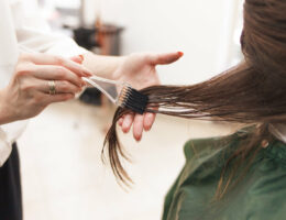 hairdresser applies a hair mask to the woman in the beauty salon. botox and keratin hair straightening procedure